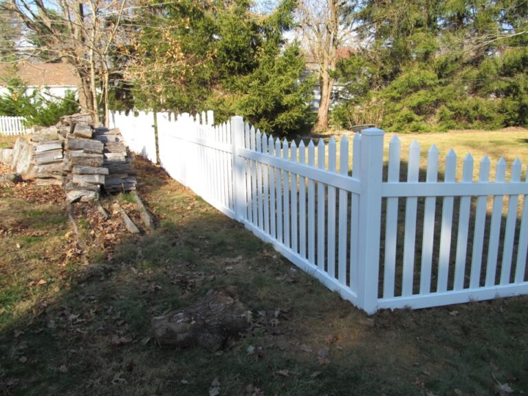 White picket fence and woodpile