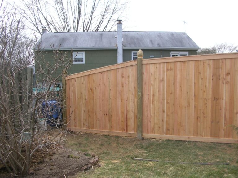 Wooden Panel Fence in front of Green House